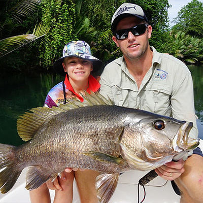 A man and his son holding up a large fish.