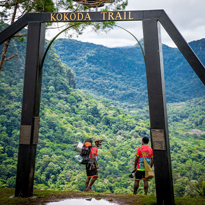 Two people walking through the Kokoda Trail Trek