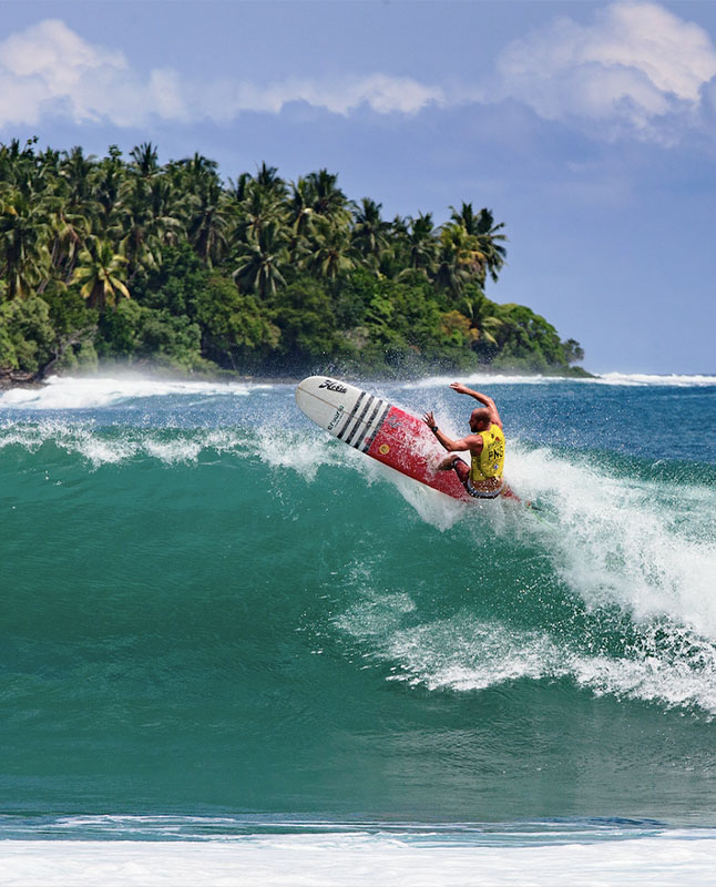 A man surfing on a wave in the ocean.