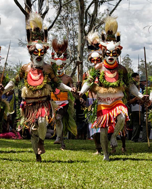 A group of individuals dancing together dressed in traditional clothing.